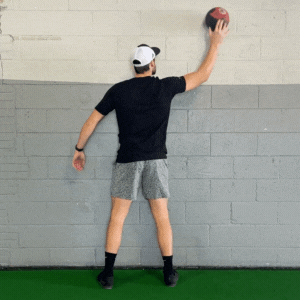 GIF of an athlete doing medicine ball wall taps exercises.