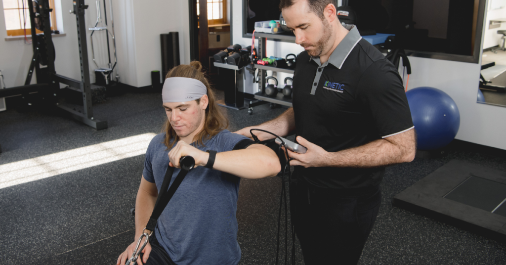 Physical therapist doing a strength test on an athlete's arm using the dynamometer.