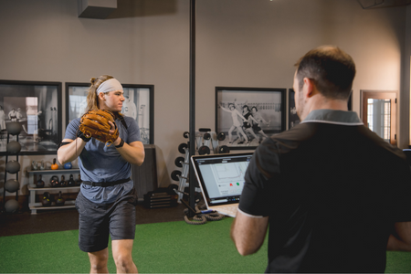 physical therapist using technology on a baseball pitcher