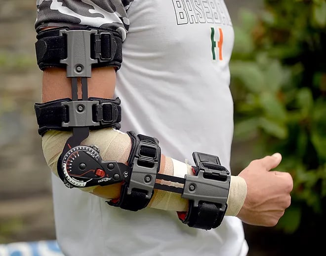 Athlete wearing a brace from wrist to shoulder after Tommy John surgery.