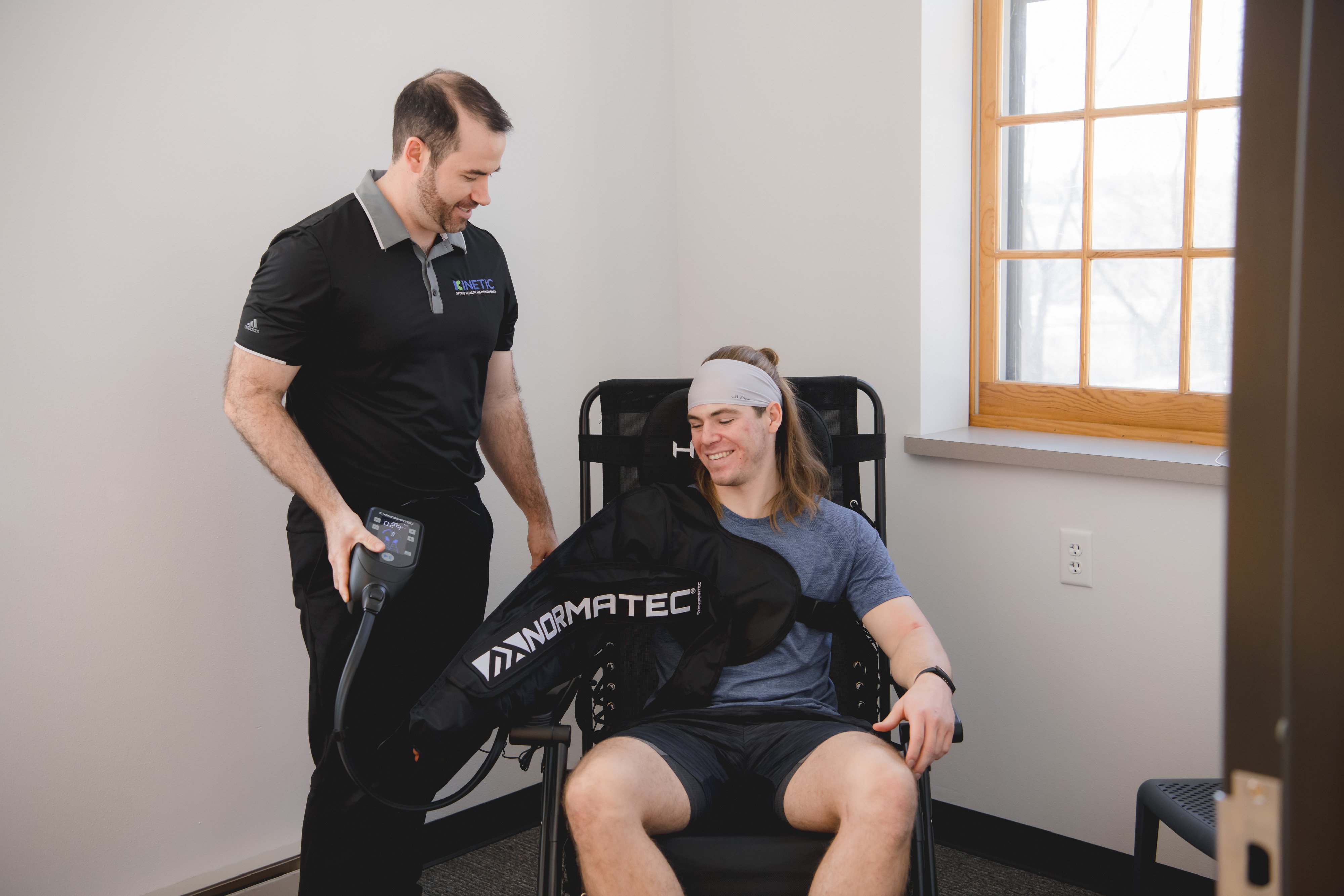 Athlete recovering with a Normatec sleeve during sports physical therapy.