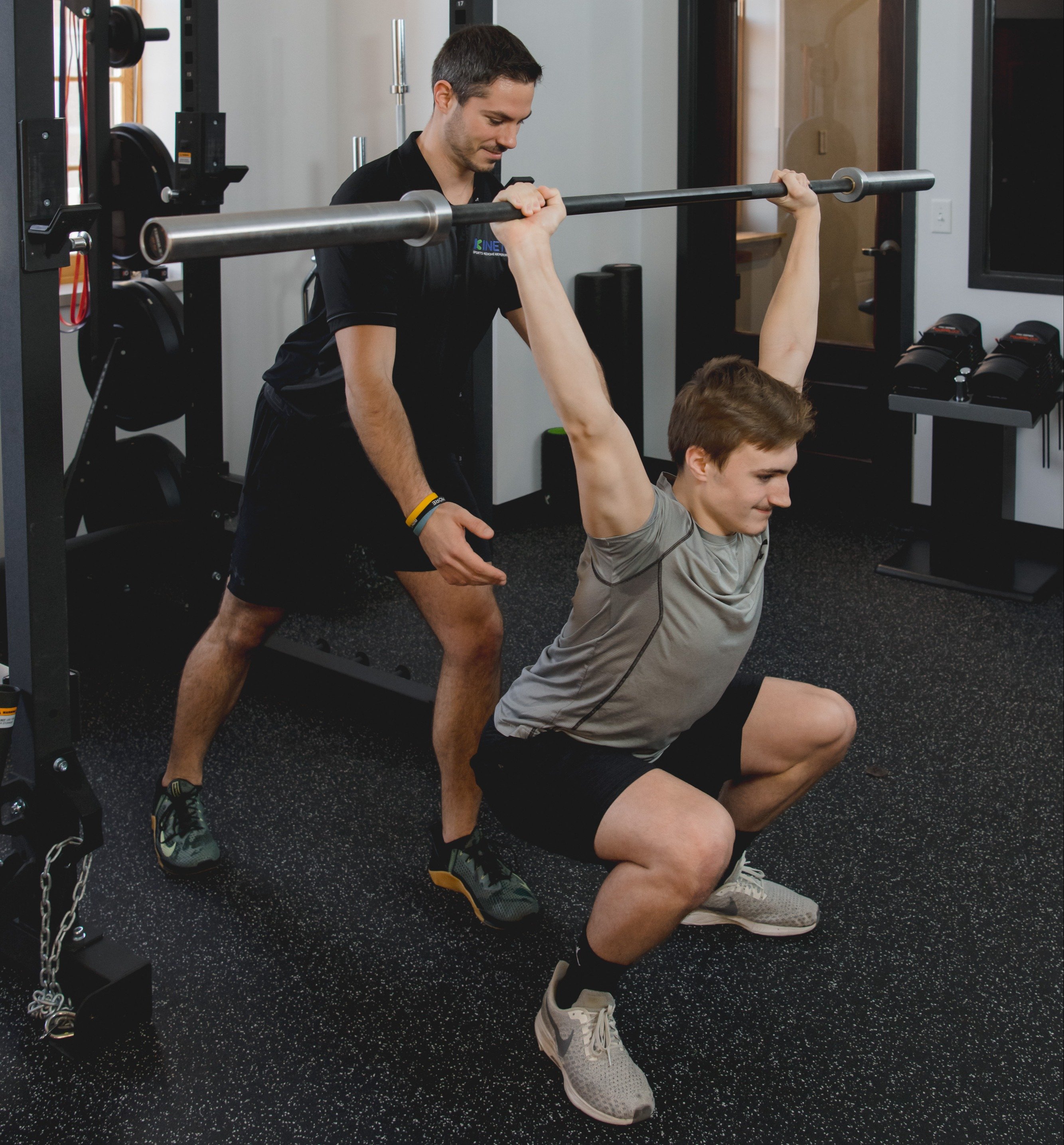 Athlete training with a barbell during sports physical therapy.