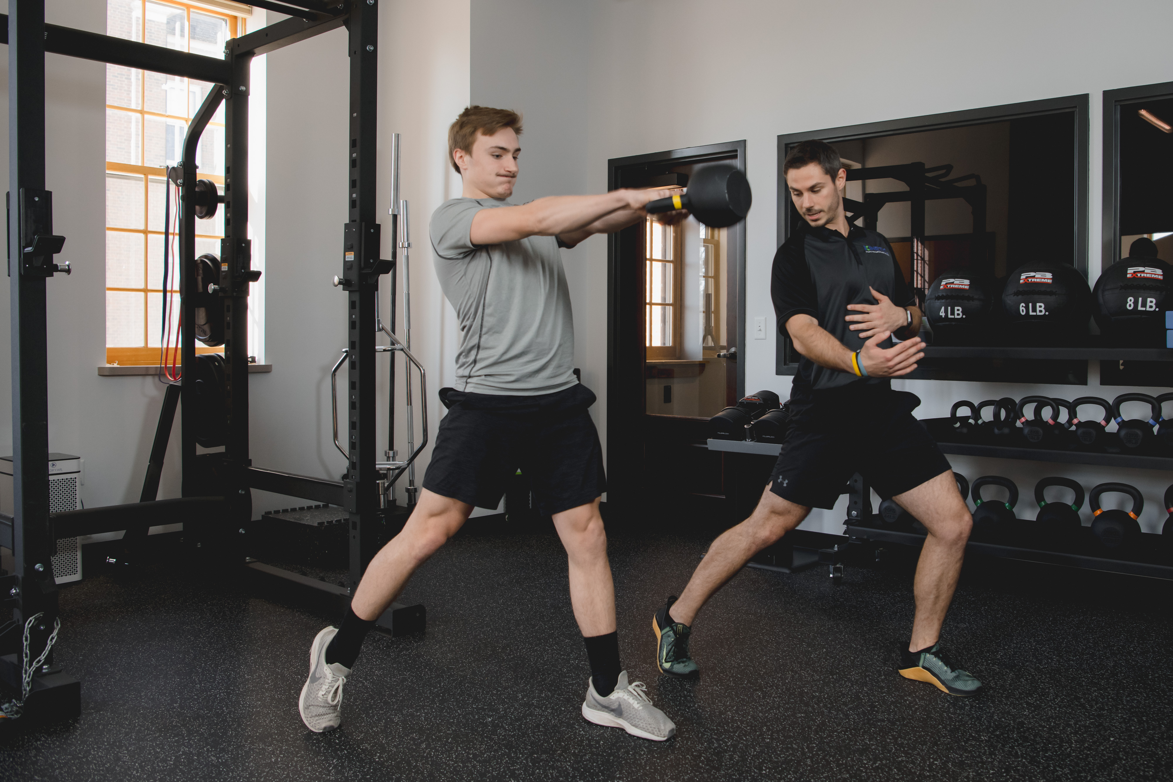 Physical therapist helping patient with kettlebell swings